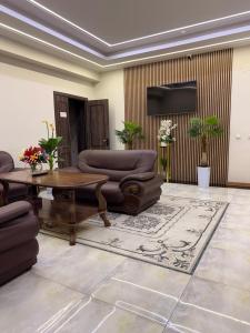 a living room with a couch and a table at Al-Xorazmiy Hotel in Urganch