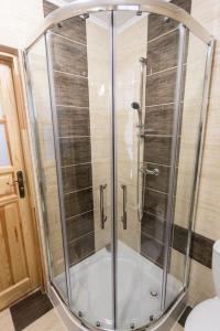 a shower with a glass enclosure in a bathroom at Domek Góralski Suche in Suche