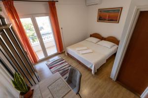 a small bedroom with a bed and a window at Apartman Lance in Kožino