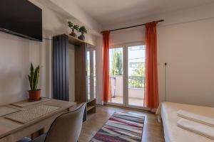 a bedroom with a bed and a desk and a window at Apartman Lance in Kožino