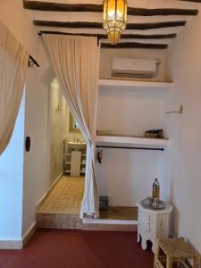 a room with a curtain and a table and a sink at Riad Patio des Amis Marrakech in Marrakesh