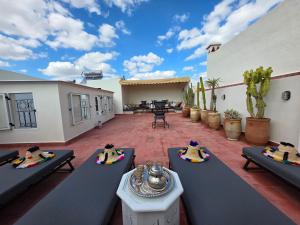 a patio with couches and tables on a courtyard at Riad Patio des Amis Marrakech in Marrakesh