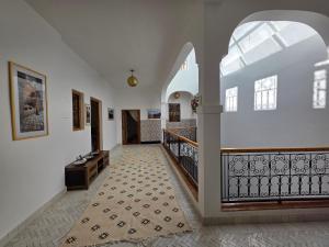 a hallway with white walls and a staircase with a tile floor at Riad Patio des Amis Marrakech in Marrakesh