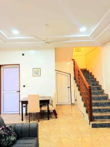 a living room with a table and a staircase at Prestige A4 in Ouagadougou +3 photos