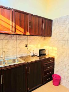 a kitchen with wooden cabinets and a microwave on a counter at Prestige A4 in Ouagadougou