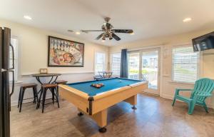 a pool table in a living room with a ceiling fan at Carolina Kai II - Kitty Hawk MP 3, 228 Yards to Beach, Ocean View, Pool, Hot Tub in Kitty Hawk