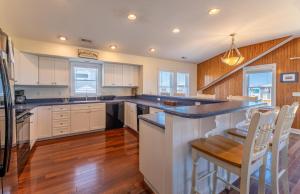 a kitchen with white cabinets and blue counter tops at Carolina Kai II - Kitty Hawk MP 3, 228 Yards to Beach, Ocean View, Pool, Hot Tub in Kitty Hawk