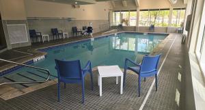 a swimming pool with chairs and a table in front of it at Comfort Inn Concord South End in Concord