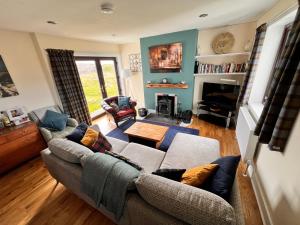 a living room with a couch and a fireplace at Taigh Tuaram in Carloway
