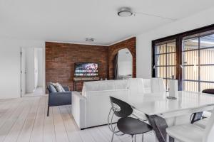 a living room with a white table and chairs at Gula villan in Påarp