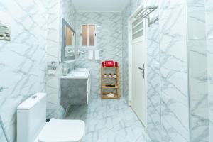 a white bathroom with a toilet and a sink at Royal Moroccan Suite Central Tangier in Tangier +38 photos