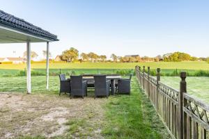a table and chairs in a field next to a fence at Gula villan in Påarp