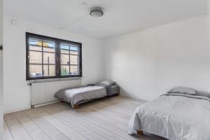 a white bedroom with a bed and a window at Gula villan in Påarp