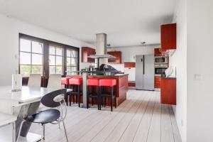 a kitchen with red chairs and a kitchen island at Gula villan in Påarp