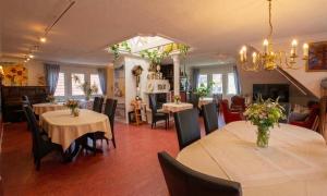 a dining room with two tables and chairs with flowers on them at Hotel Im Schwedischen Hof in Binz