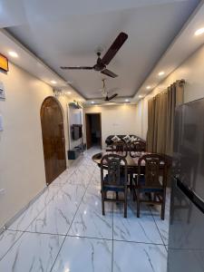 a dining room with a table and chairs and a couch at Orchid 3BHK 3AC in New Town