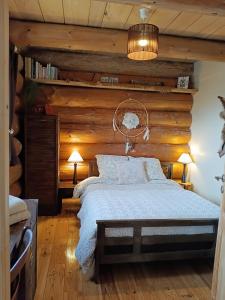 a bedroom with a wooden wall and a bed at Lagarta La Fuste in Étival
