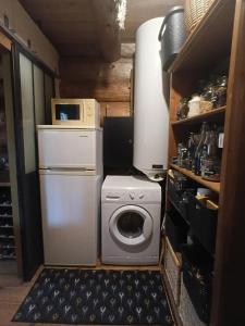 a kitchen with a washing machine and a microwave at Lagarta La Fuste in Étival