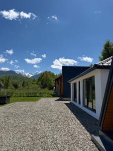 a house with a gravel driveway with mountains in the background at The DREAM A-frame Cabin in Arpaşu de Sus