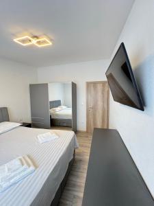 a room with two beds and a tv on the wall at Apartments Šebin in Baška Voda