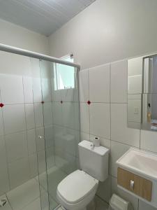 a white bathroom with a toilet and a sink at Pousada Baia dos Golfinhos in Governador Celso Ramos +29 photos