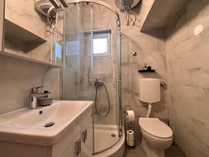 a bathroom with a shower and a sink and a toilet at Apartments Šebin in Baška Voda +15 photos