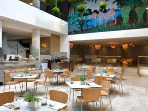 a restaurant with tables and chairs and a cafeteria at Pullman Kinshasa Grand Hotel in Kinshasa