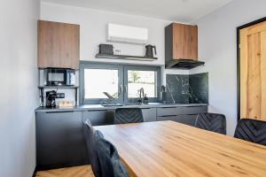 a kitchen with a wooden table and a kitchen counters at Maruszyna Resort & SPA in Zakopane +231 photos