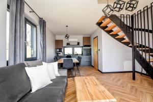 a living room with a couch and a staircase at Maruszyna Resort & SPA in Zakopane