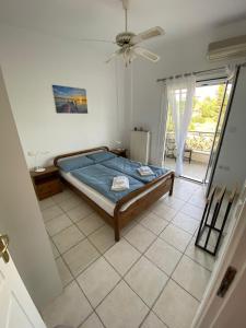 ein Schlafzimmer mit einem Bett auf einem gefliesten Boden in der Unterkunft Evia Blue by Sofia in Lefkandi Chalkida