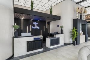 a lobby with a waiting area with potted plants at Red Lion Inn & Suites Kansas City in Kansas City +66 photos