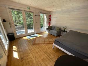 a bedroom with a bed and a couch in a room at Peaceful Forest Cabin in Nature in Paluküla