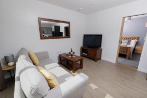 a living room with a couch and a television at Bellevue Apartment, Shetland Islands in Whiteness