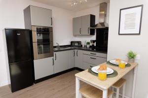 a kitchen with a table and a black refrigerator at Bellevue Apartment, Shetland Islands in Whiteness