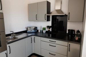 a kitchen with white cabinets and a black counter top at Bellevue Apartment, Shetland Islands in Whiteness +21 photos