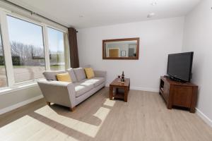 a living room with a couch and a tv at Bellevue Apartment, Shetland Islands in Whiteness