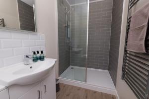 a bathroom with a shower and a sink and a tub at Bellevue Apartment, Shetland Islands in Whiteness