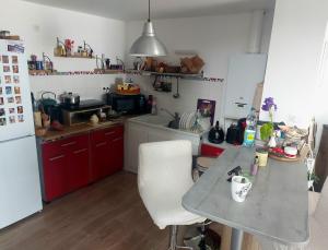 a small kitchen with a table and a refrigerator at Coutances in Coutances