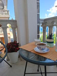 a table with a cup of coffee on a balcony at Apartmani Peace in Krašići