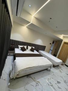 a bedroom with two beds and a marble floor at Hotel D Lite Inn in Junagadh