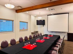 a conference room with a long table and chairs and a screen at Super 8 by Wyndham Castlegar BC in Castlegar