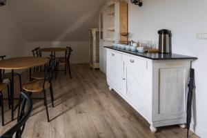 a kitchen with a counter and a table and chairs at Mitter-ház Panzió in Zalaszentgrót