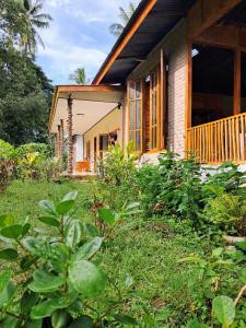 a small house with a porch and a yard at Lonthar B&B - Adults Only in Riung