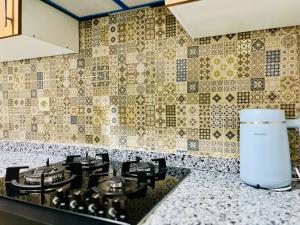 a kitchen counter with a stove and a tile wall at Appartement Climatisé 2 Chambres à Marrakech Proche Golf & Jamaâ El Fna in Marrakesh +17 photos