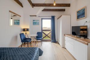 a bedroom with a bed and a tv and a table at Rezydencja nad rzeką in Łeba +26 photos