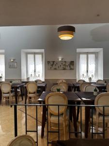 a dining room with tables and chairs and windows at Hotel Spagna in Arona