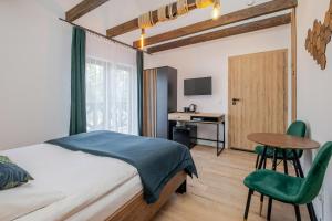 a bedroom with a bed and a desk and a table at Rezydencja nad rzeką in Łeba