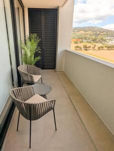 a balcony with two chairs and a table and a window at Increible departamento en Punto Sur in Los Gavilanes