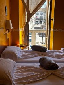 two beds in a room with a window at Hotel Spagna in Arona