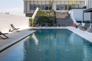 a swimming pool in front of a building with stairs at Increible departamento en Punto Sur in Los Gavilanes